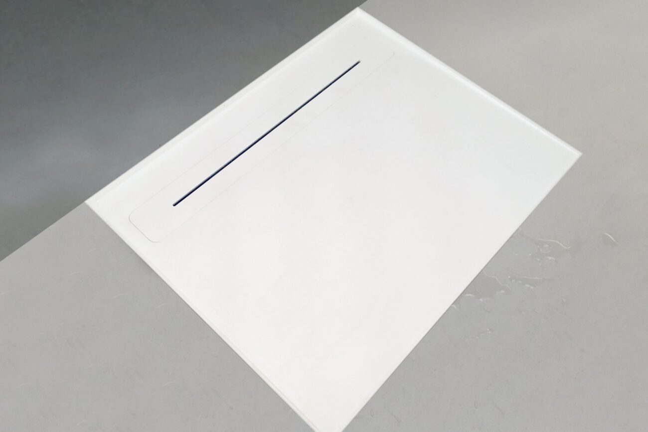 Bodenebene Duschflaeche mit integrierter, schmaler Duschrinne mit Waermetauscher für einen dezenten und modernen Ablauf