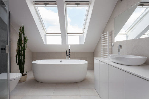 Helles, modernes Badezimmer mit freistehender Badewanne und Dachfenstern – Symbol für die Arbeit des Haustechnikers, der Haustechnik, Energieeffizienz und Wohnkomfort ganzheitlich verbindet.