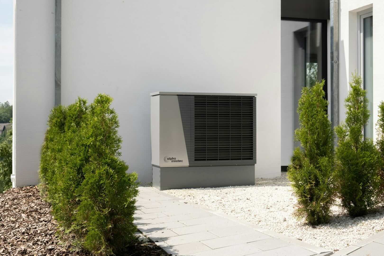 Außenaufgestellte Wärmepumpe an einem Wohngebäude als Beispiel für die Heizungsplanung und Bauausführung von Energieberatung Christensen inklusive individueller Heizlastberechnung und Förderfähigkeit.