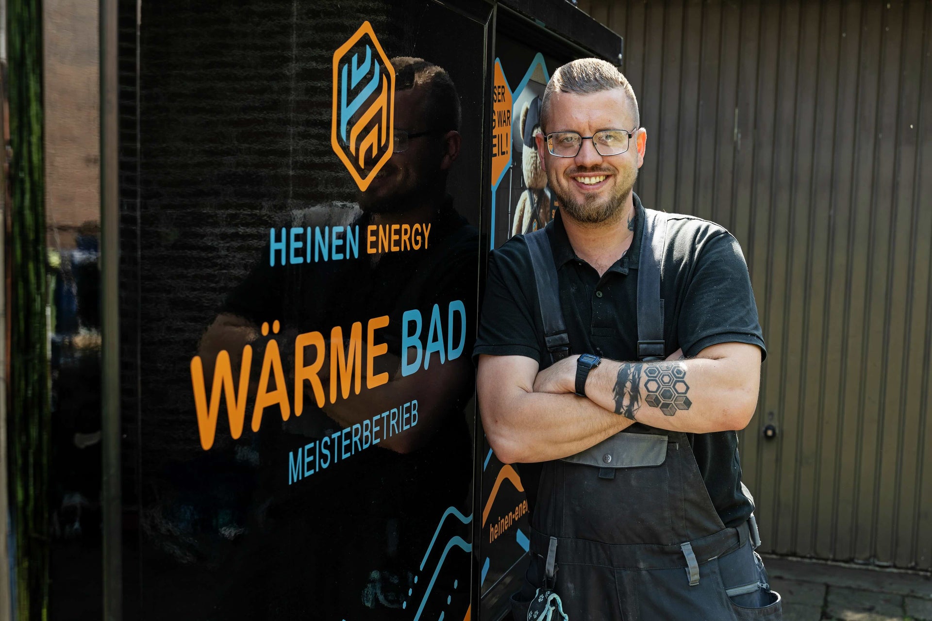 SHK-Meister von Heinen Energy vor Firmenfahrzeug mit Leistungsübersicht zu Badsanierung, Heiztechnik, Wärmerückgewinnung und Smart-Home-Integration