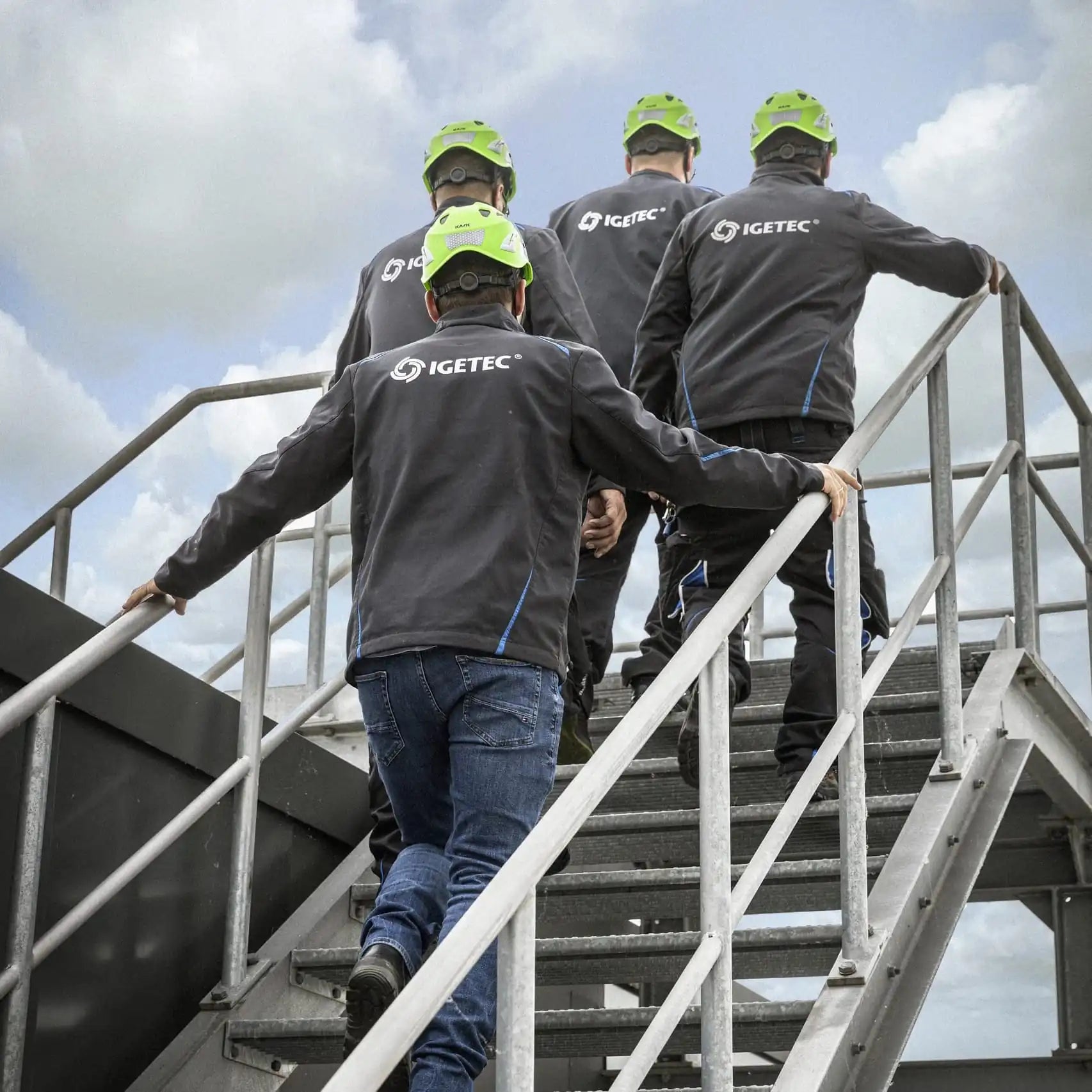Techniker von IGETEC Energie- und Umwelttechnik mit Schutzhelmen bei der Arbeit an einer Industrieanlage – Umsetzung ganzheitlicher, energieeffizienter Gebäudetechnik in den Bereichen Heizung, Sanitär, Lüftung und Energiemanagement
