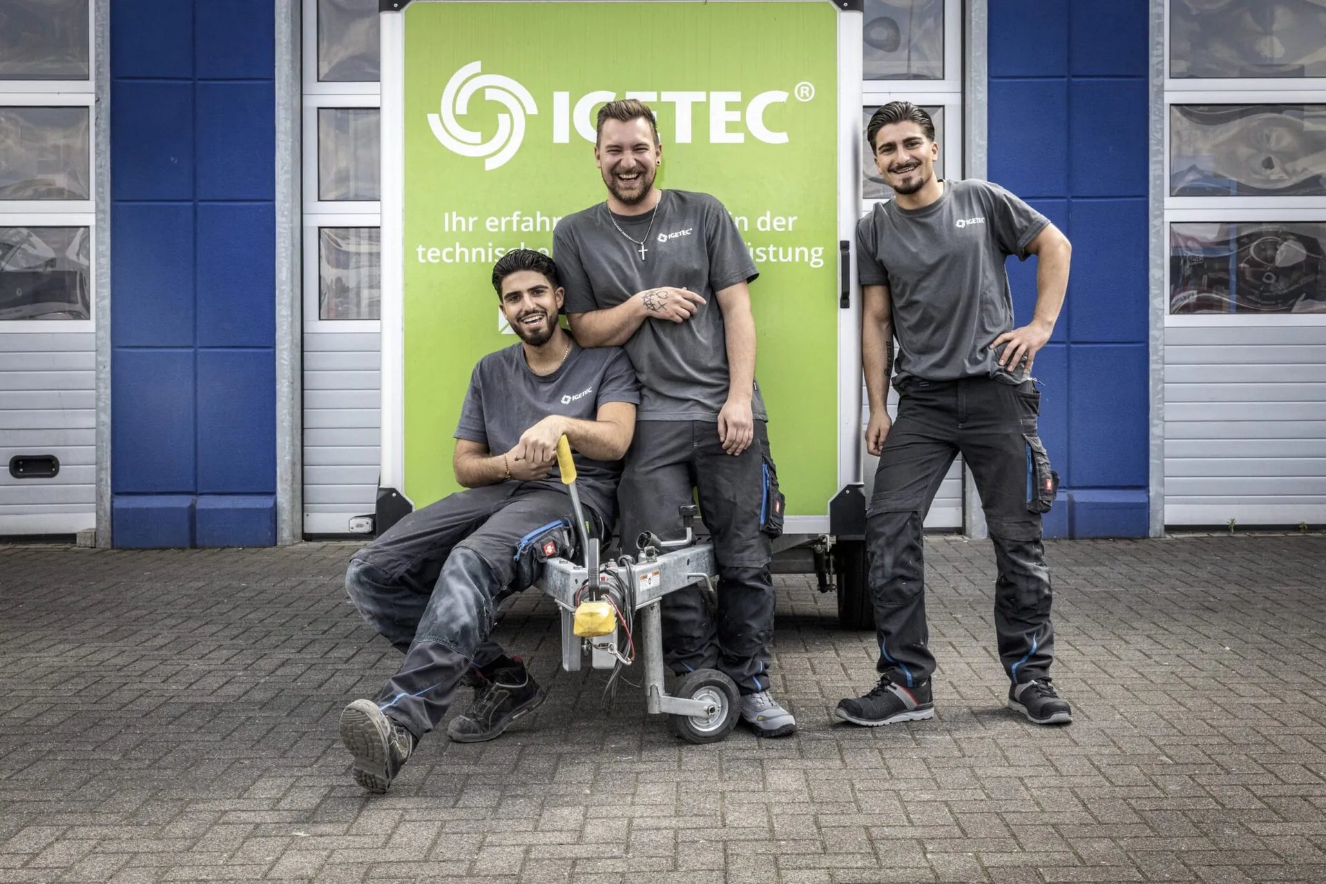 Team von IGETEC Energie- und Umwelttechnik vor einem Firmenfahrzeug – Fachkräfte für energieeffiziente Gebäudetechnik und innovative Wärmerückgewinnungssysteme beim Duschen in Zusammenarbeit mit Unocconi