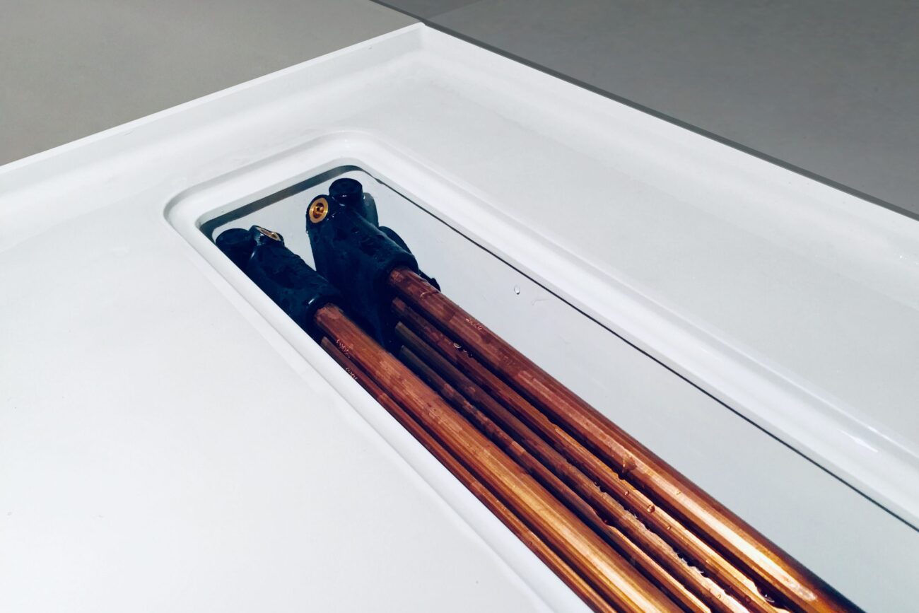 Geöffnete Twinline Duschrinne mit sichtbaren Kupferwärmetauschern nach längerem Gebrauch, zeigt den robusten Aufbau und die dauerhaft funktionierende Wärmerückgewinnung im Duschbereich.