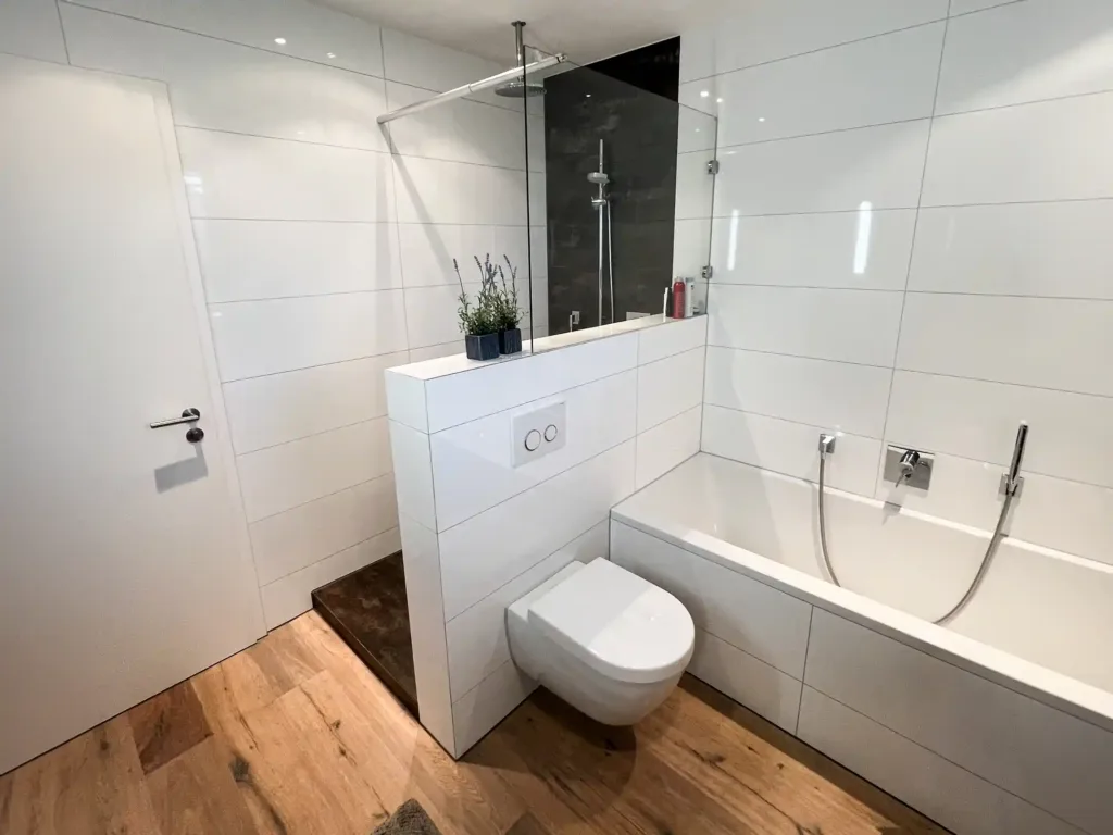 Modernes, hochwertig saniertes Badezimmer der Walz Badmanufaktur in Stuttgart mit bodengleicher Dusche, Glasabtrennung, klaren Linien und zeitlosem Design – Beispiel für professionelle Badmodernisierung und Komplettbadsanierung durch einen Unocconi Partnerbetrieb.