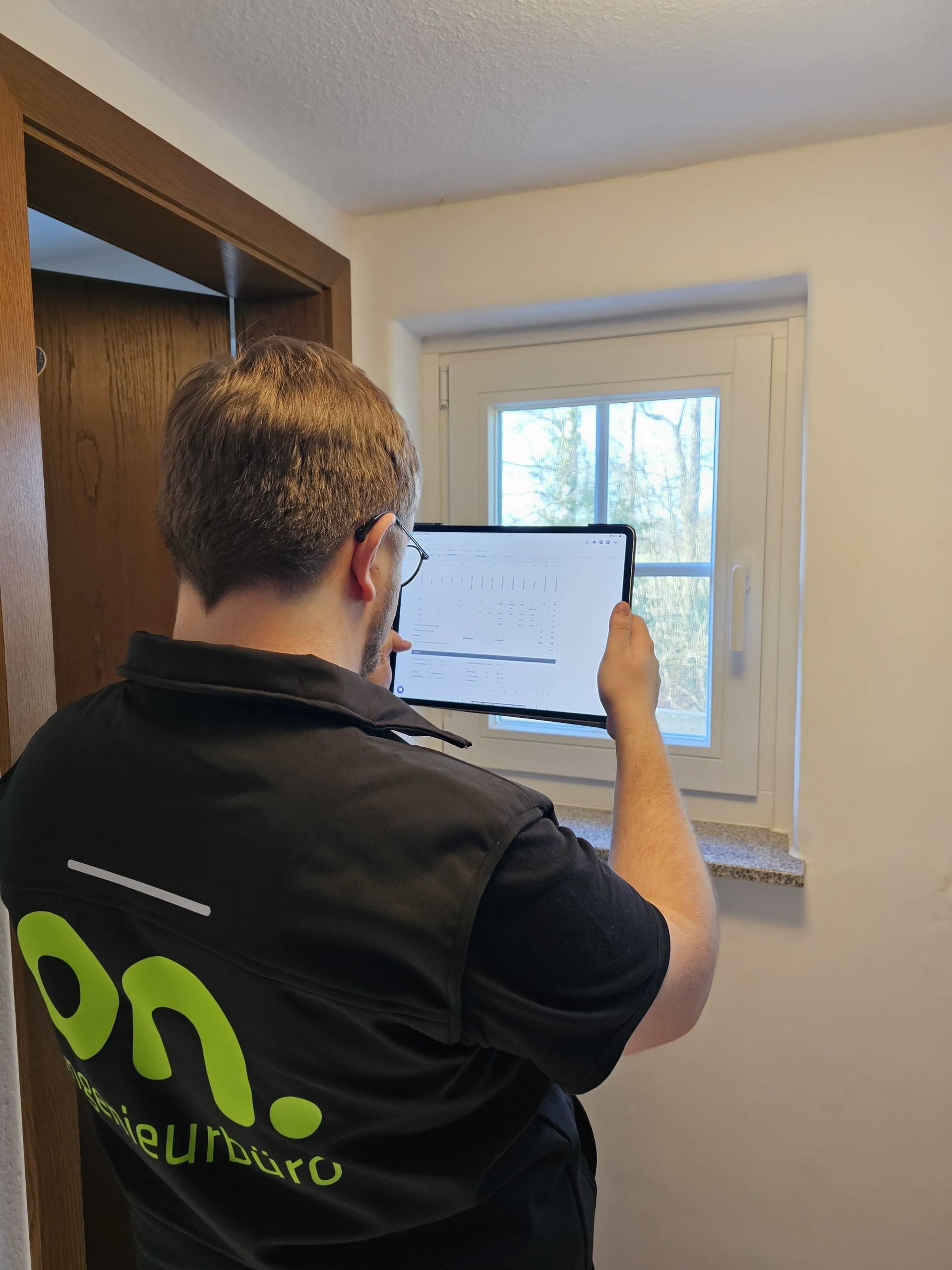 Energieberater des on. ingenieurbüros analysiert ein Wohngebäude vor Ort mit Tablet als Grundlage für den individuellen Sanierungsfahrplan (iSFP) und eine effiziente energetische Sanierung.